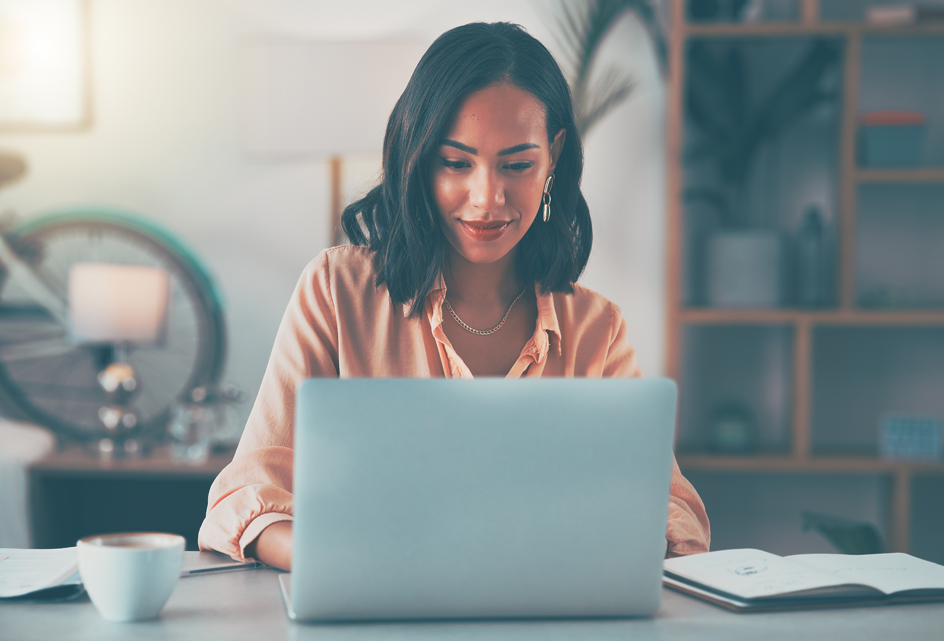 woman looks at a laptop screen and smiles